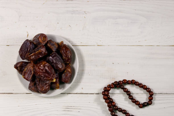 istock Dates fruit and prayer beads on white wooden table. Top view 960166454
