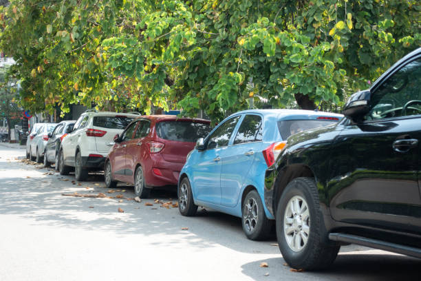 istock Parallel cars parking on street with green trees 960166896