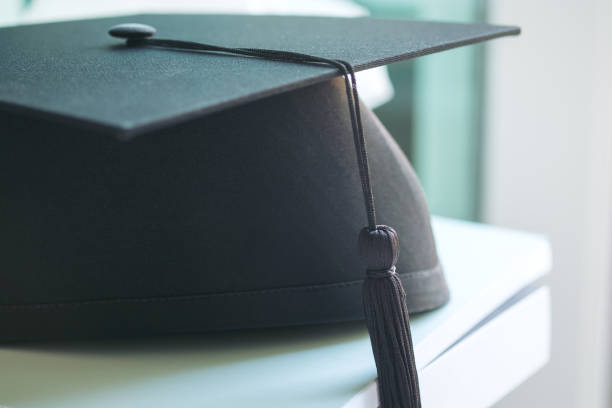 istock A black graduation hat on white books and background 960171026