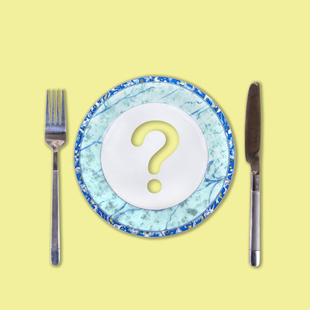 istock Question mark on an empty white-blue plate with fork and knife on gently yellow background, concept of diet, top view 960173148