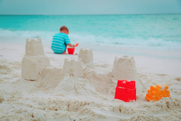 istock little boy building castle play with sand on beach 960175614