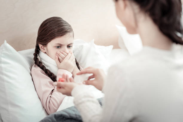 istock Ill girl covering her mouth 960176216