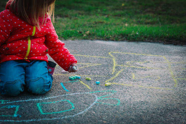 istock little girl drawing with chalks on playground 960176234