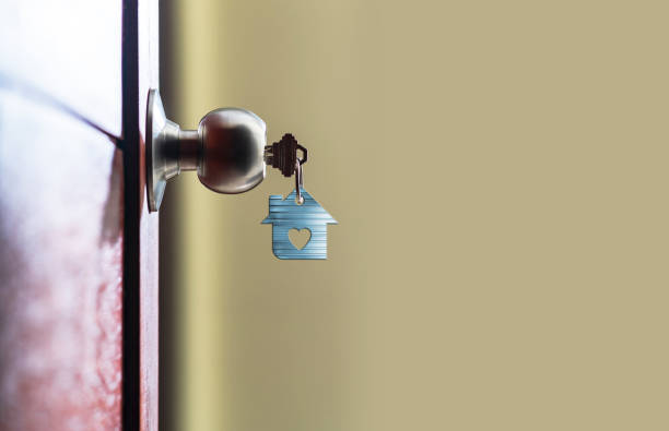 Open door with keys, House key in keyhole with small house