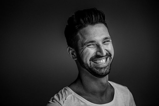 Young bearded man portrait. Fine film grain texture. Studio shot.