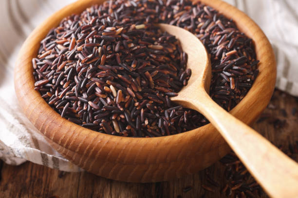 istock Natural Foods: Raw wild black rice macro in a wooden bowl. Horizontal 960184286