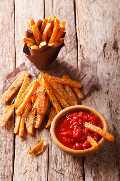 istock fried sweet potato wedges with herbs and ketchup close-up. Vertical 960184322