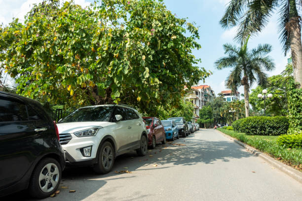 istock Parallel cars parking on street with green trees 960185526