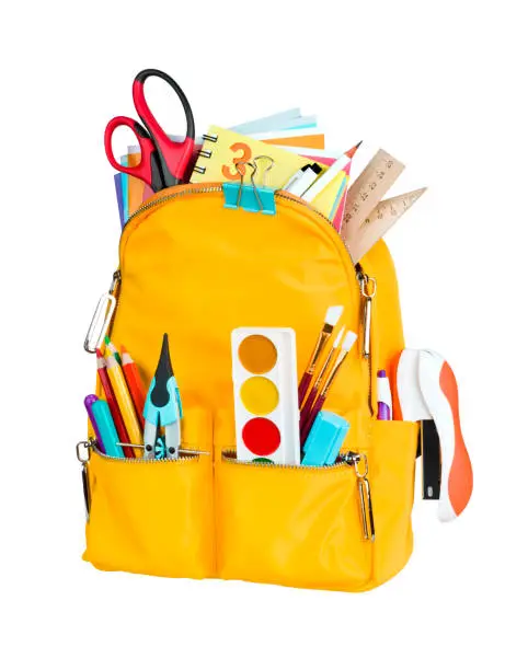 Photo of Yellow school backpack with school supplies isolated on white background