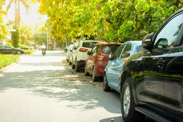 istock Parallel cars parking on street with green trees 960189168