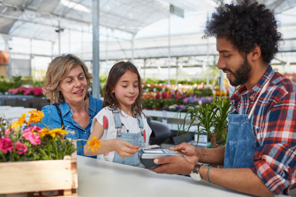 muchacha de pagos nfc con tarjeta para jardinero - florist telephone flower business fotografías e imágenes de stock