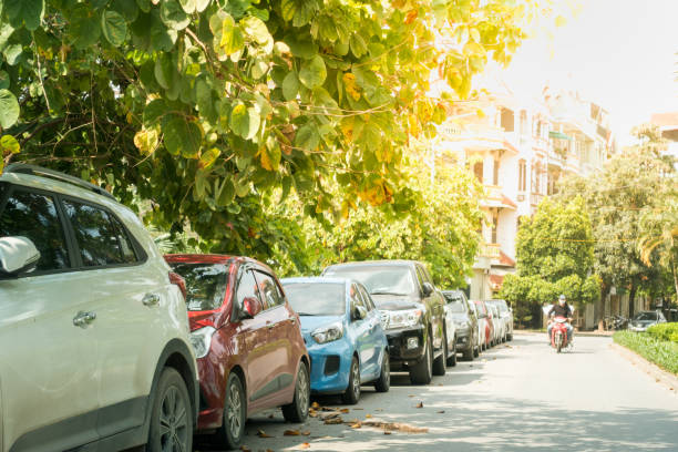 istock Parallel cars parking on street with green trees 960194286