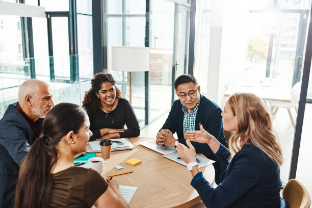 Putting plans into motion Shot of a group of businesspeople having a meeting in an office coworker stock pictures, royalty-free photos & images
