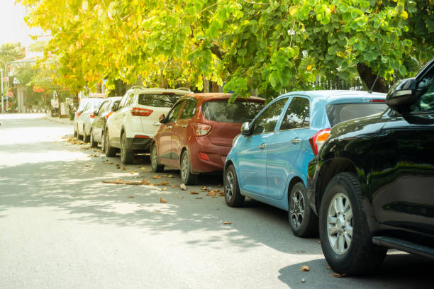 istock Parallel cars parking on street with green trees 960195298