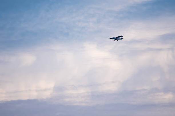 Small plane in the air. Blue sky with white clouds