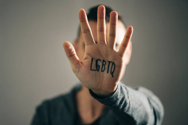istock man with the text LGBTQ in his hand 960196412