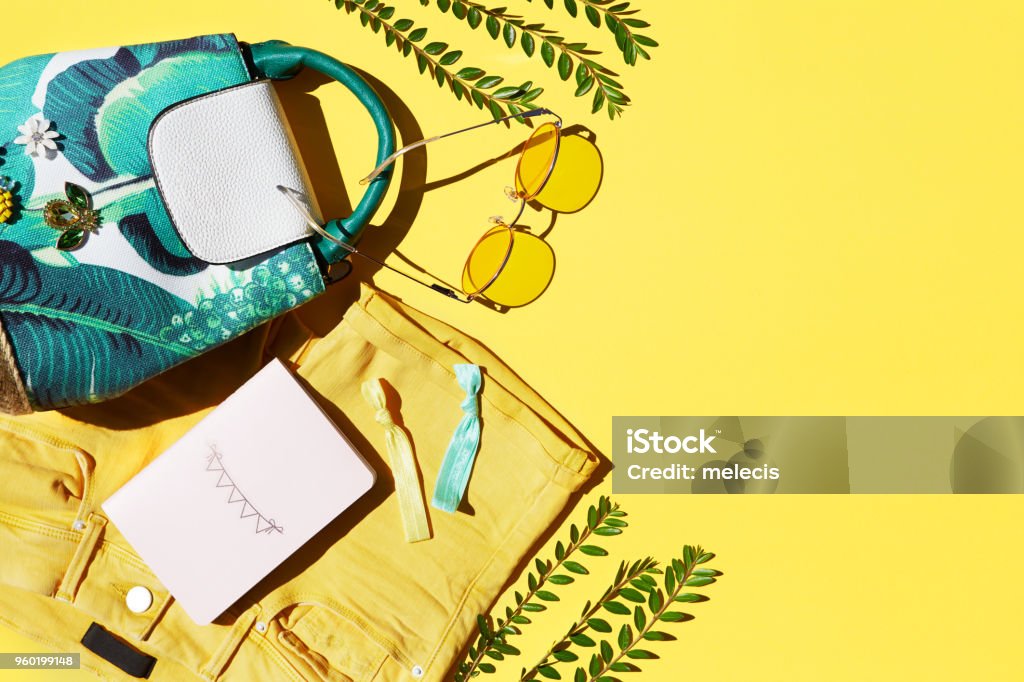 Flat Lay Of Female Holiday Clothing And Accessories summer, fashion, women, clothing, yellow, backgrounds, sunglasses, backpack, shorts, notepad Summer Stock Photo
