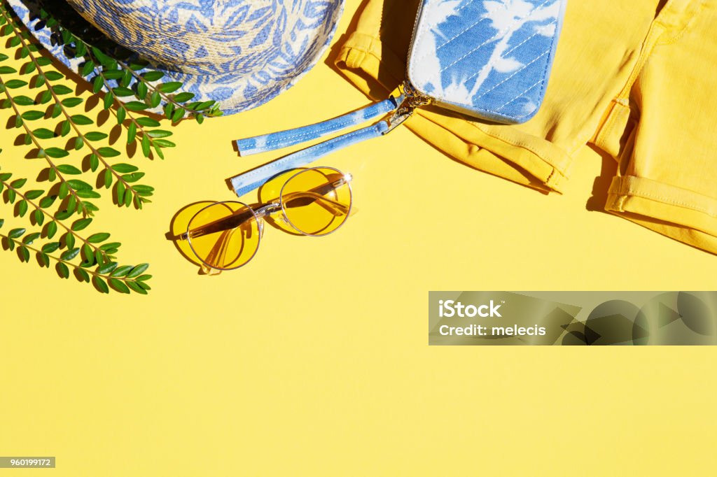 Flat Lay Shot Of Female Holiday Clothing And Accessories summer, fashion, women, clothing, yellow, backgrounds, sunglasses, hat, shorts Summer Stock Photo
