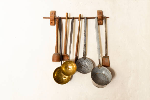 Retro style set of different wooden and metal kitchen spoons and tools hanging on a wall