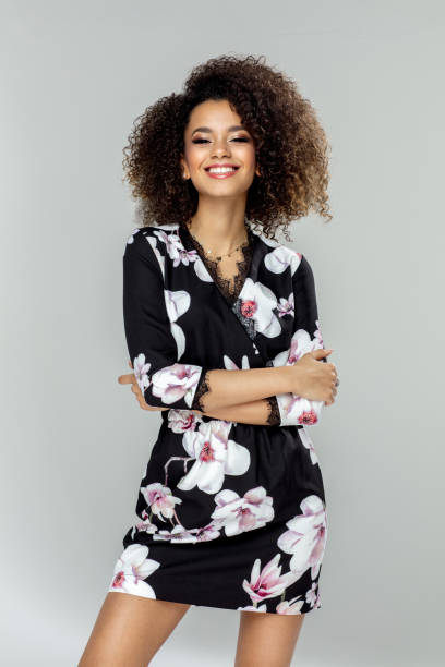 Beautiful happy african american young female model wear dress in flowers Beautiful african american young female model smiling dress stock pictures, royalty-free photos & images