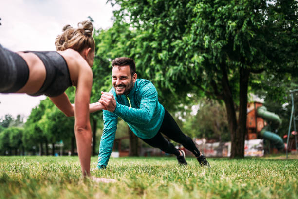 istock Young couple doing one hand push-up exercise in the park. 960209346