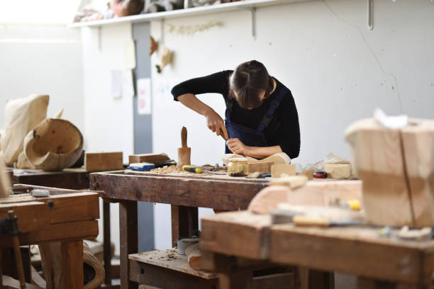 Young Female Sculptor is working in her studio Young Female Sculptor is working in her studio carpenter carpentry craftsperson carving stock pictures, royalty-free photos & images
