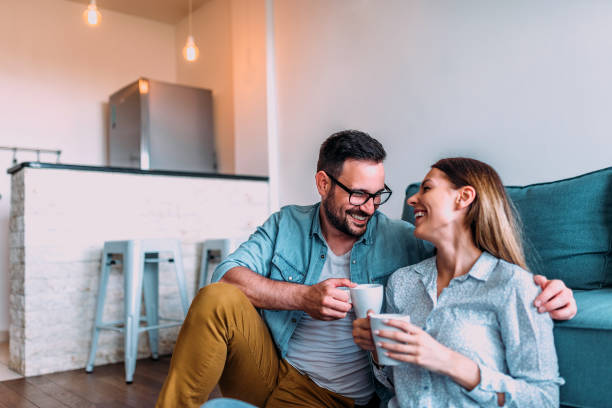 istock Couple relaxing at home, drinking coffee or tea while sitting on the floor. 960209496
