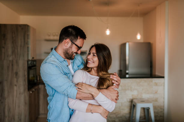 Happy couple in their new home. Young couple hugging indoors. Happy couple in their new home. Young couple hugging indoors. two people embracing stock pictures, royalty-free photos & images