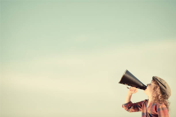 kid shouting through megaphone - marketing megaphone child using voice imagens e fotografias de stock