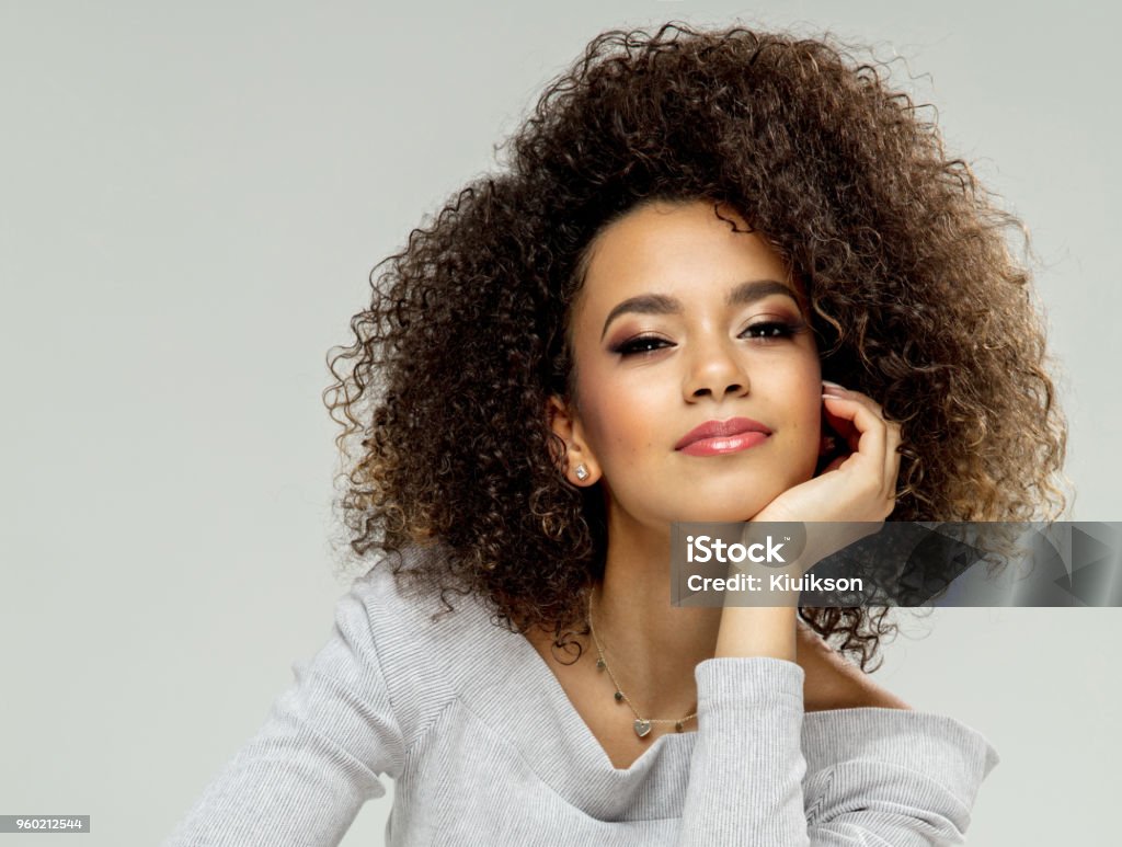 Beautiful black woman Fashion portrait of black woman sitting on chair, isolated on grey background Women Stock Photo