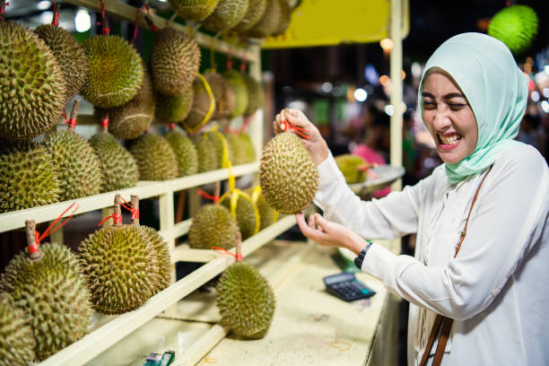 Malaysian woman holding Durian fruit known for its smell. Malaysian woman holding Durian fruit known for its smell. lahore pakistan photos stock pictures, royalty-free photos & images