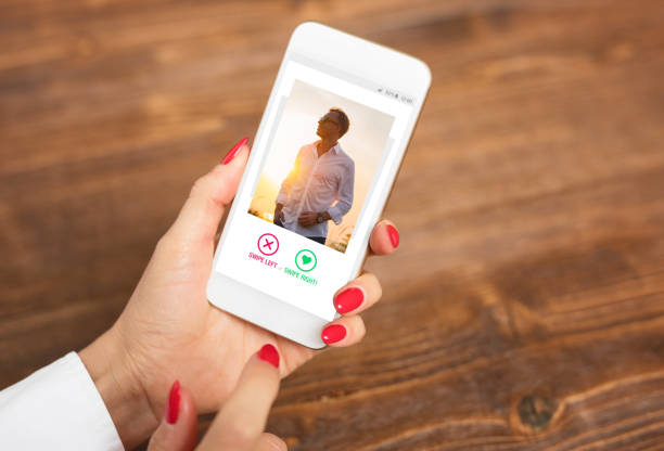 kobieta za pomocą aplikacji randkowej i przesuwając zdjęcia użytkowników - internet dating zdjęcia i obrazy z banku zdjęć
