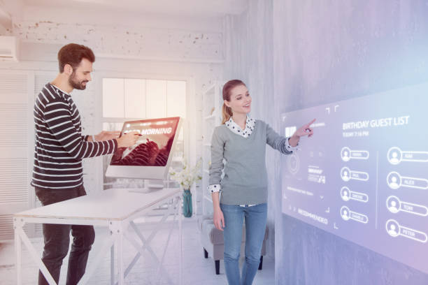 istock Smiling woman pointing to a screen while her colleague working on computer 960213242
