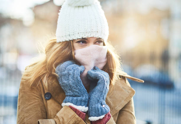 It's cold out here, I have to cover up Shot of an attractive young woman enjoying being out in the snow coat garment photos stock pictures, royalty-free photos & images
