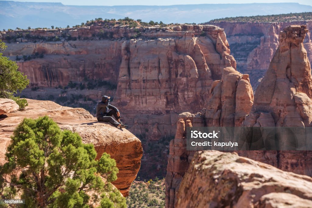 Turista sedí na útesu v Coloradském národním památníku, USA - Bez autorských poplatků Batoh Stock fotka Turista sedí na útesu v Coloradském národním památníku, USA - Bez autorských poplatků Batoh Stock fotka