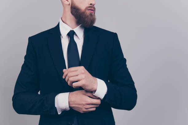 przycięty z bliska portret eleganckiego pewnego siebie poważnego surowego surowego lidera udanego profesjonalnego męskiego finansisty freelancera dostosowującego cufflinks na rękawie odizolowanym na szarym tle - chain smoking zdjęcia i obrazy z banku zdjęć