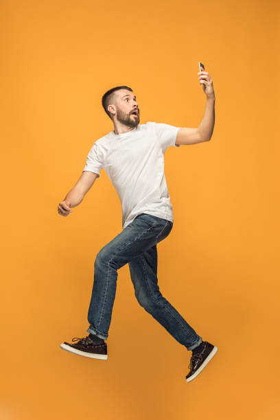 istock Full length of handsome young man taking selfie while jumping 960221228