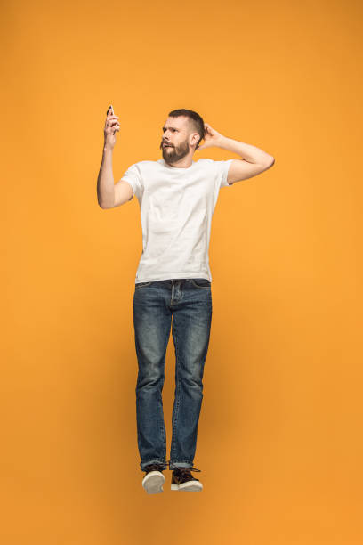 istock Full length of handsome young man taking selfie while jumping 960221282