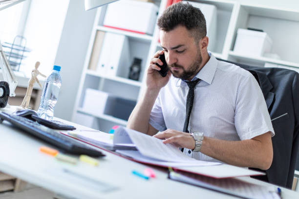 istock A man is sitting in the office, working with documents and talking on the phone. 960223376