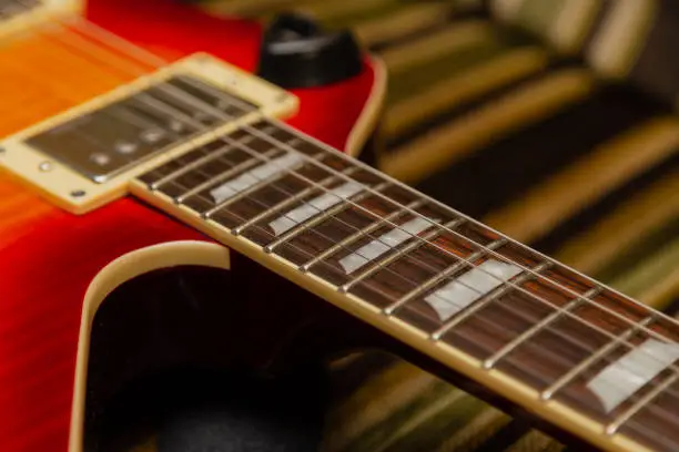 Photo of Electric guitar body and neck detail on wooden background vintage look