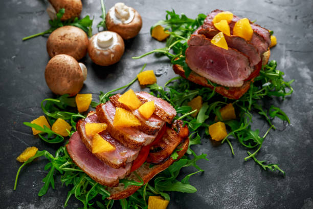 istock Duck breast steak slices on wild rocket pillow sandwich with orange bits, mushrooms and balsamic vinegar drizzle 960226780