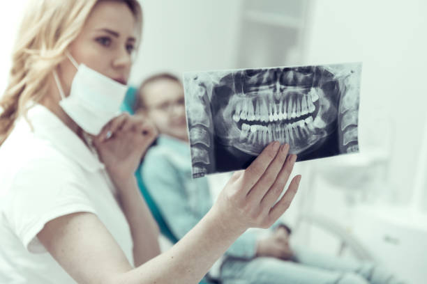 resultados de una radiografía en las manos de un dentista joven - dental issues fotografías e imágenes de stock