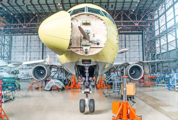 Passenger airplane on maintenance of engine and fuselage check repair in airport hangar. With an open hood on the nose under the cockpit of pilots. Passenger airplane on maintenance of engine and fuselage check repair in airport hangar. With an open hood on the nose under the cockpit of pilots airplane part stock pictures, royalty-free photos & images