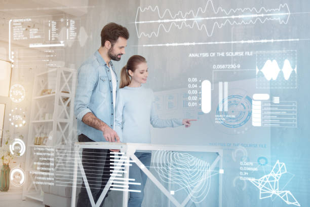 istock Clever woman showing statistics while standing next to her kind husband 960232254