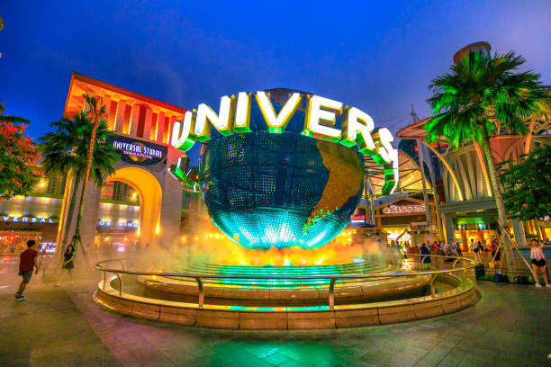 Sentosa Universal Studios Singapore - May 2, 2018: Universal Studios world globe in green light, with tourists visiting this Hollywood movie theme park in Sentosa island. orlando florida stock pictures, royalty-free photos & images