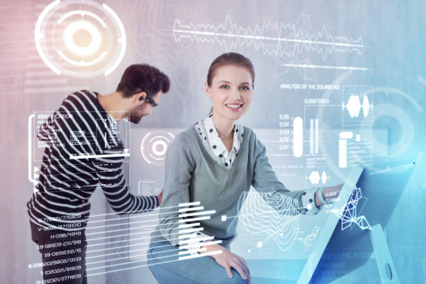 istock Young designer sitting near her computer while a busy colleague working near 960232734