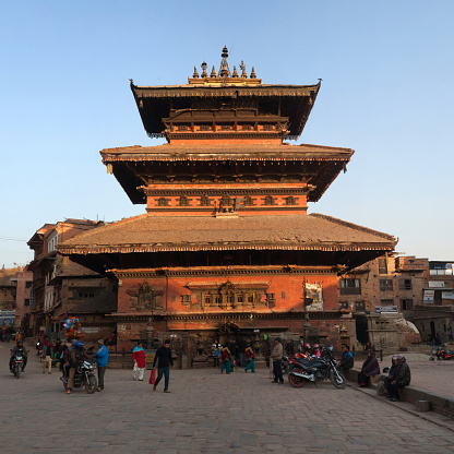 Bhaktapur, Nepal - January 23, 2017: Local people and tourists walking at Durbar square. Ancient famous Bhairavnath hindu temple in background