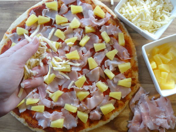 spalmazione del formaggio sulla pizza - human hand baked food pineapple foto e immagini stock