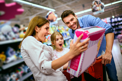 Family with one child shopping together in toy store.