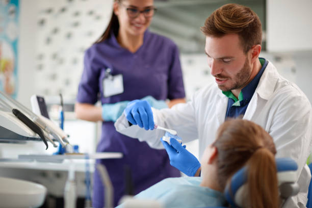 dentist showing properly brushing teeth to girl in ambulant - ambulant patient imagens e fotografias de stock